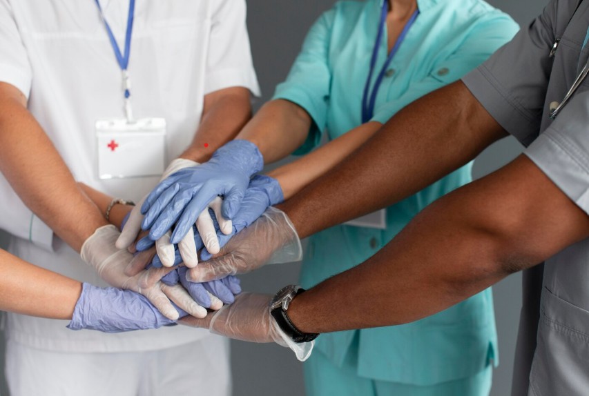 Médicos y enfermeria tomándose las manos en actitud de solidaridad